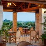 Terrazza di hotel con vista sul paesaggio e arredi in legno chiaro