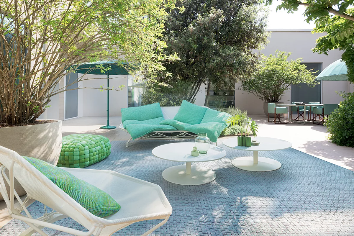 Patio moderno con arredi verde menta e vegetazione rigogliosa