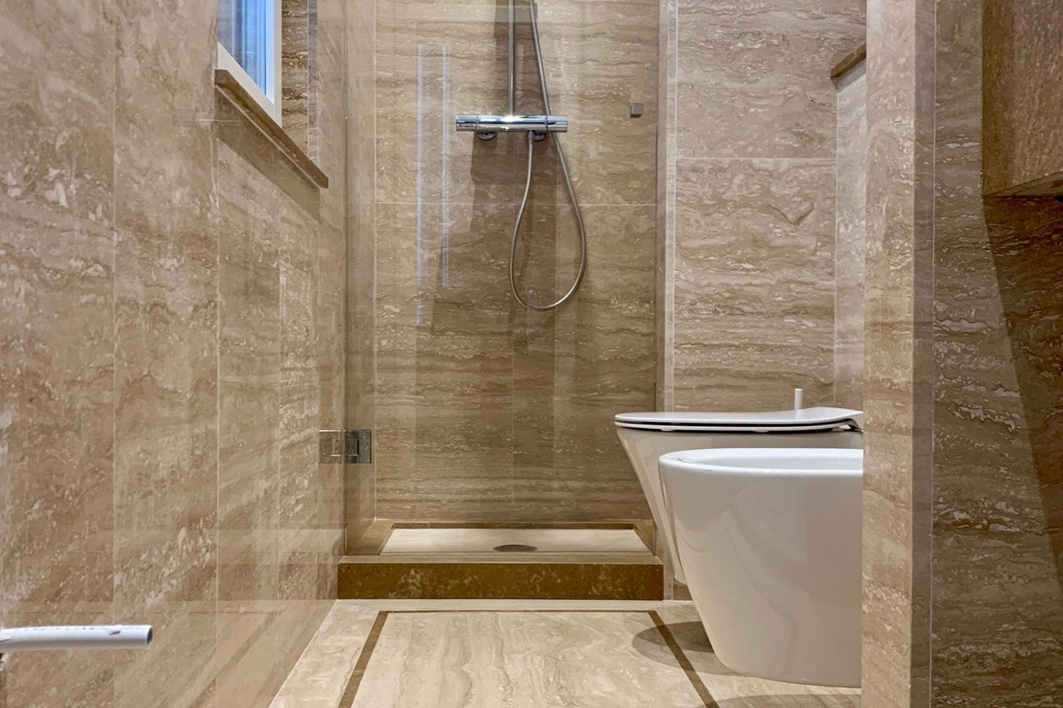 Travertino in bagno pareti, lavabo e superfici continue