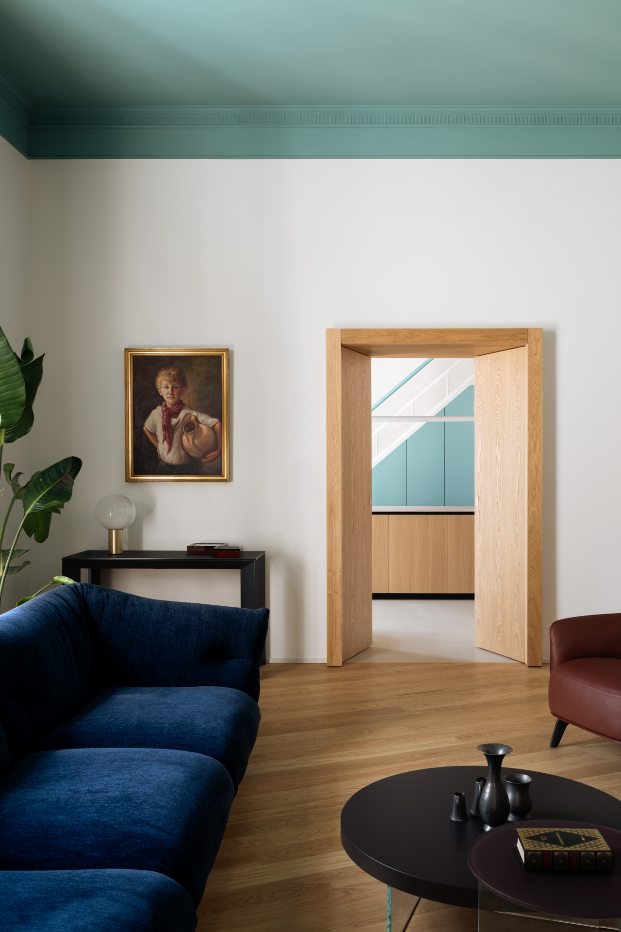 Casa Iolascon living room with an aqua ceiling, blue sofa and timber floor