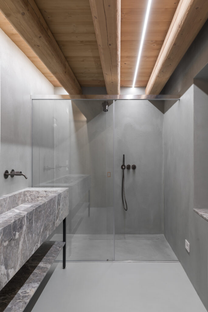 Bagno con lavabo monolitico in pietra grigia a Casa EB
