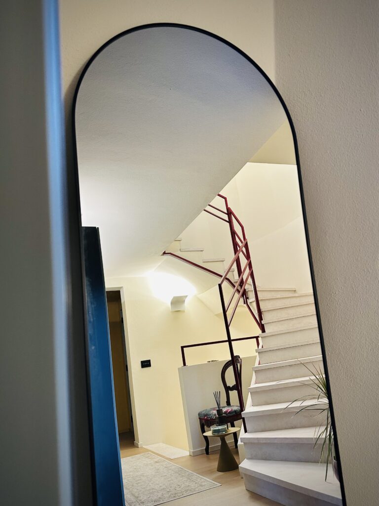 Specchio ad arco e scala verso lo studio musicale di Villa Fumane