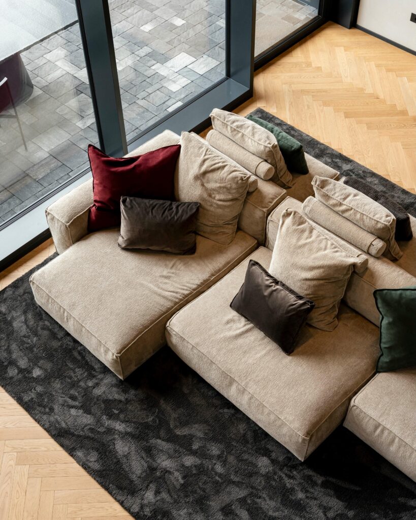 Living di House B con parquet a spina di pesce e luce naturale