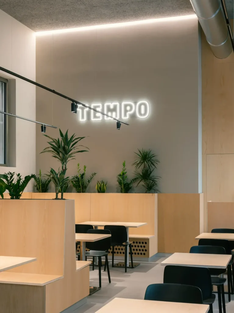 Sala con arredi in frassino e insegna al neon del ristorante TEMPO