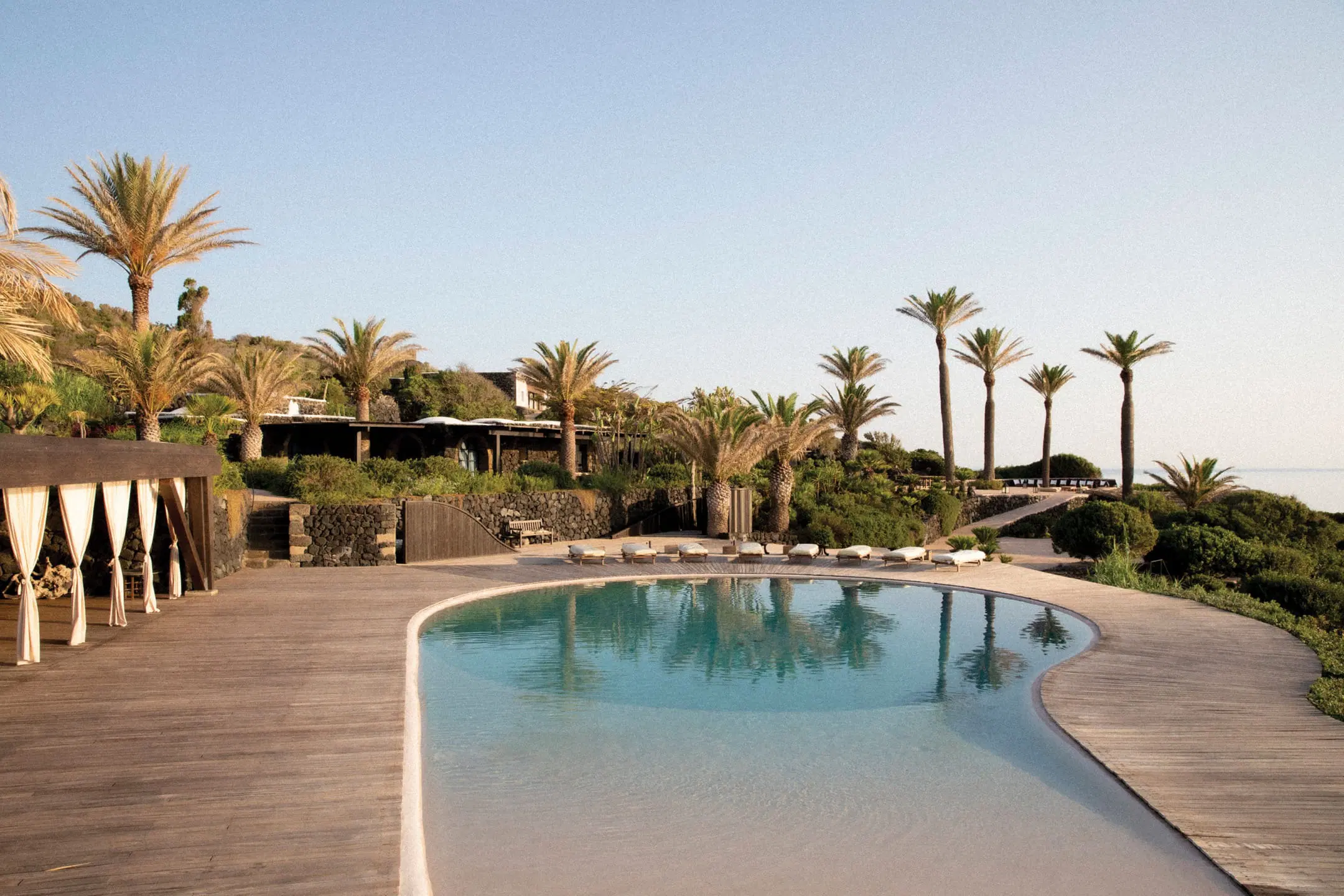 Piscina a virgola circondata da palme a Pantelleria