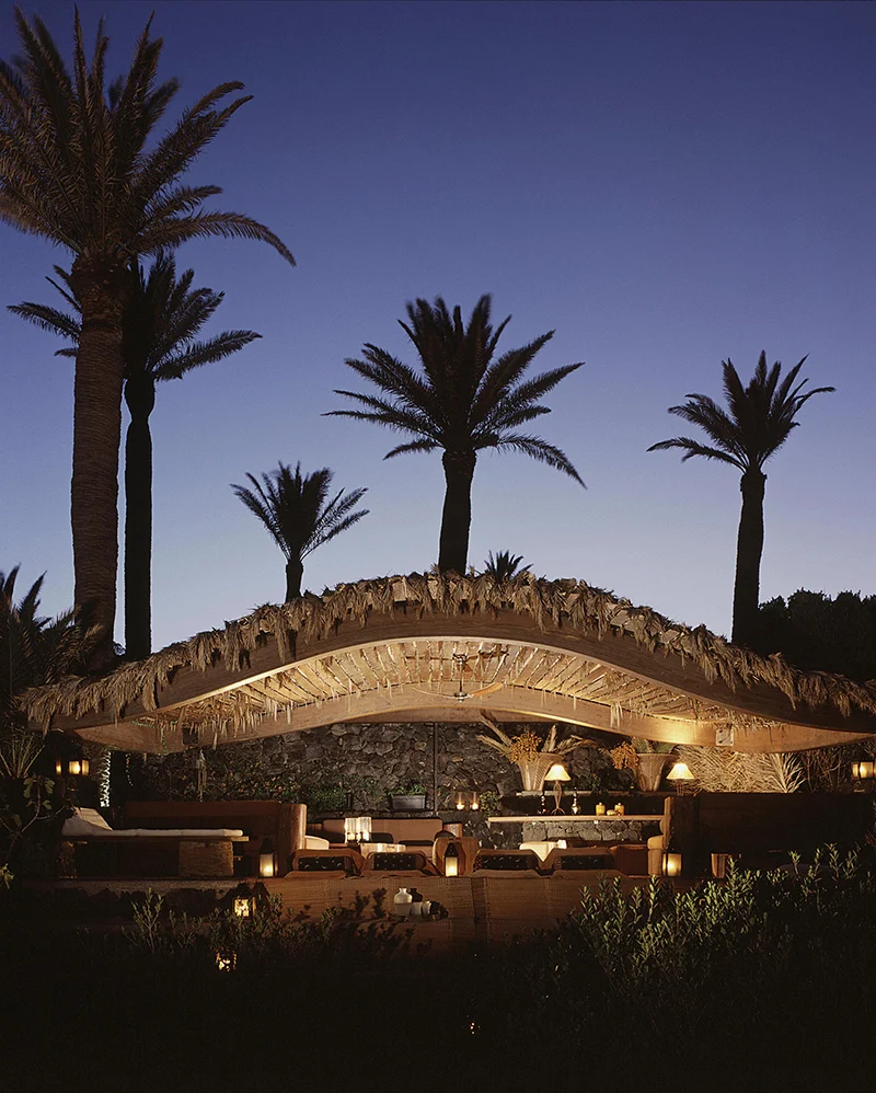 Terrazza con pergola e palme al crepuscolo tra i dammusi di Pantelleria