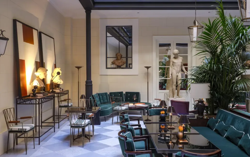Salone di Casa J.K. Place Roma con divani, tavoli e opere d’arte