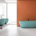 Vasca freestanding turchese davanti a una parete color terracotta
