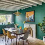 Sala da pranzo di 12th Street Townhouse con pareti verdi, sedie senape e travi bianche