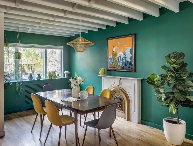 Sala da pranzo di 12th Street Townhouse con pareti verdi, sedie senape e travi bianche