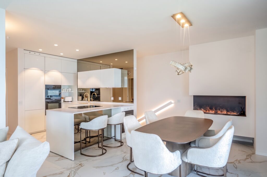 Open space di Casa K+K con cucina bianca e camino, progetto Sara Morgante