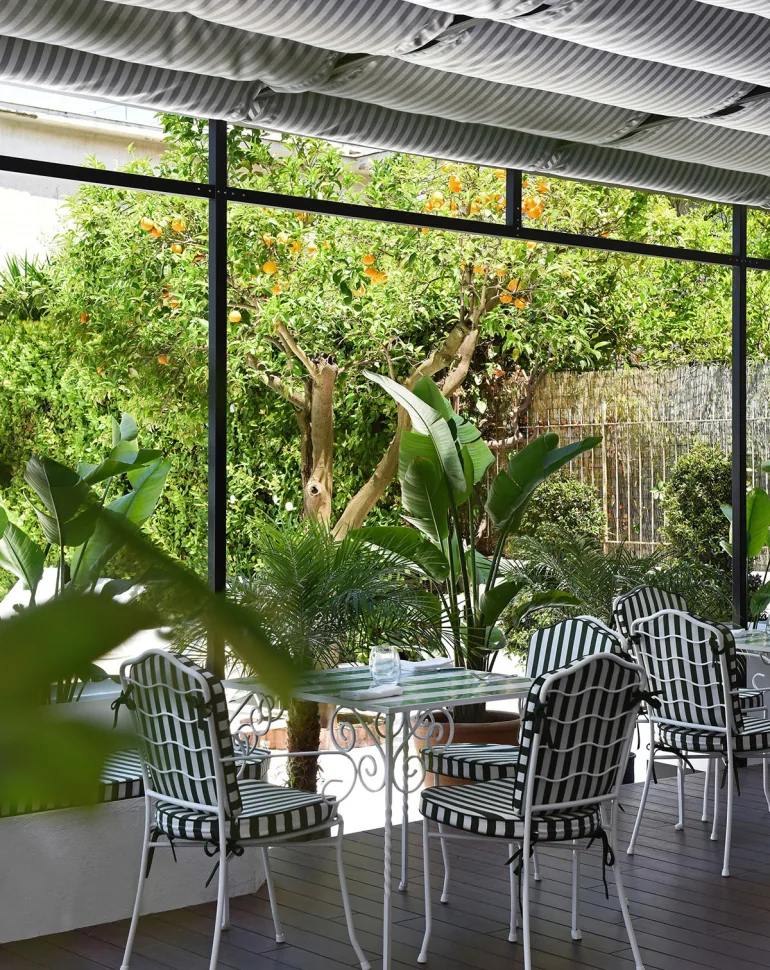 Spazio verde del Grand Hotel Flora con sedute a righe tra la vegetazione
