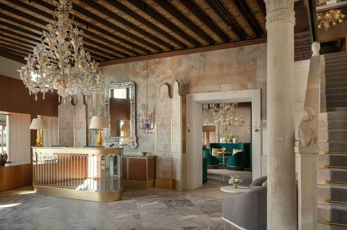 Lobby dell'Hotel Gabrielli a Venezia con scala monumentale, lampadari di Murano e sedute verdi