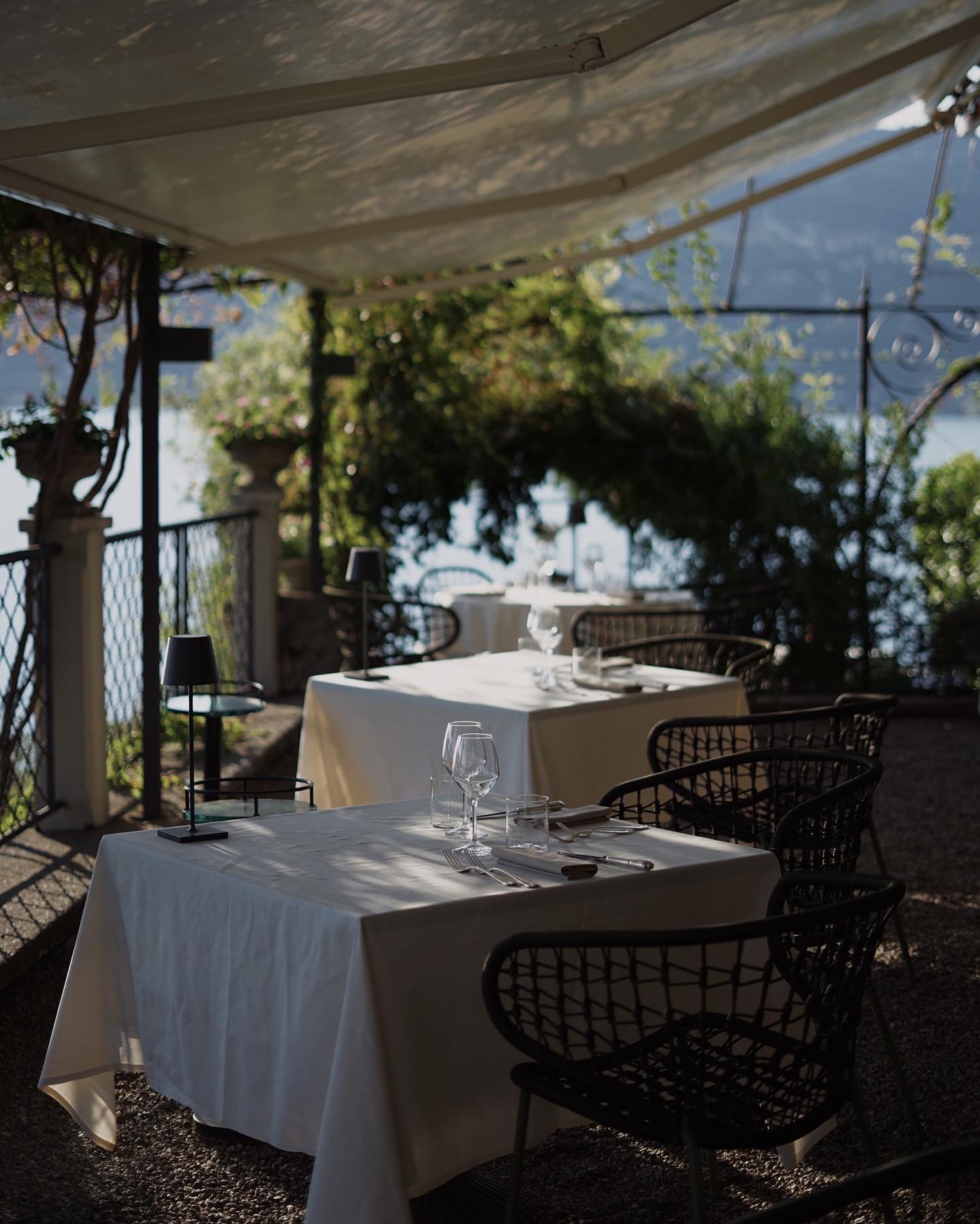 Tables beneath the leafy pergola at Il Sole di Ranco, overlooking Lake Maggiore.