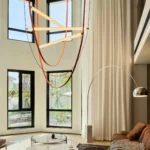 Soggiorno a doppia altezza con illuminazione decorativa e lampade Flos