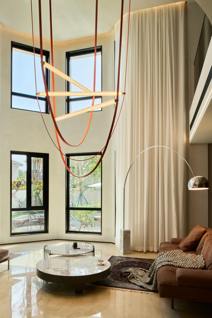 Soggiorno a doppia altezza con illuminazione decorativa e lampade Flos