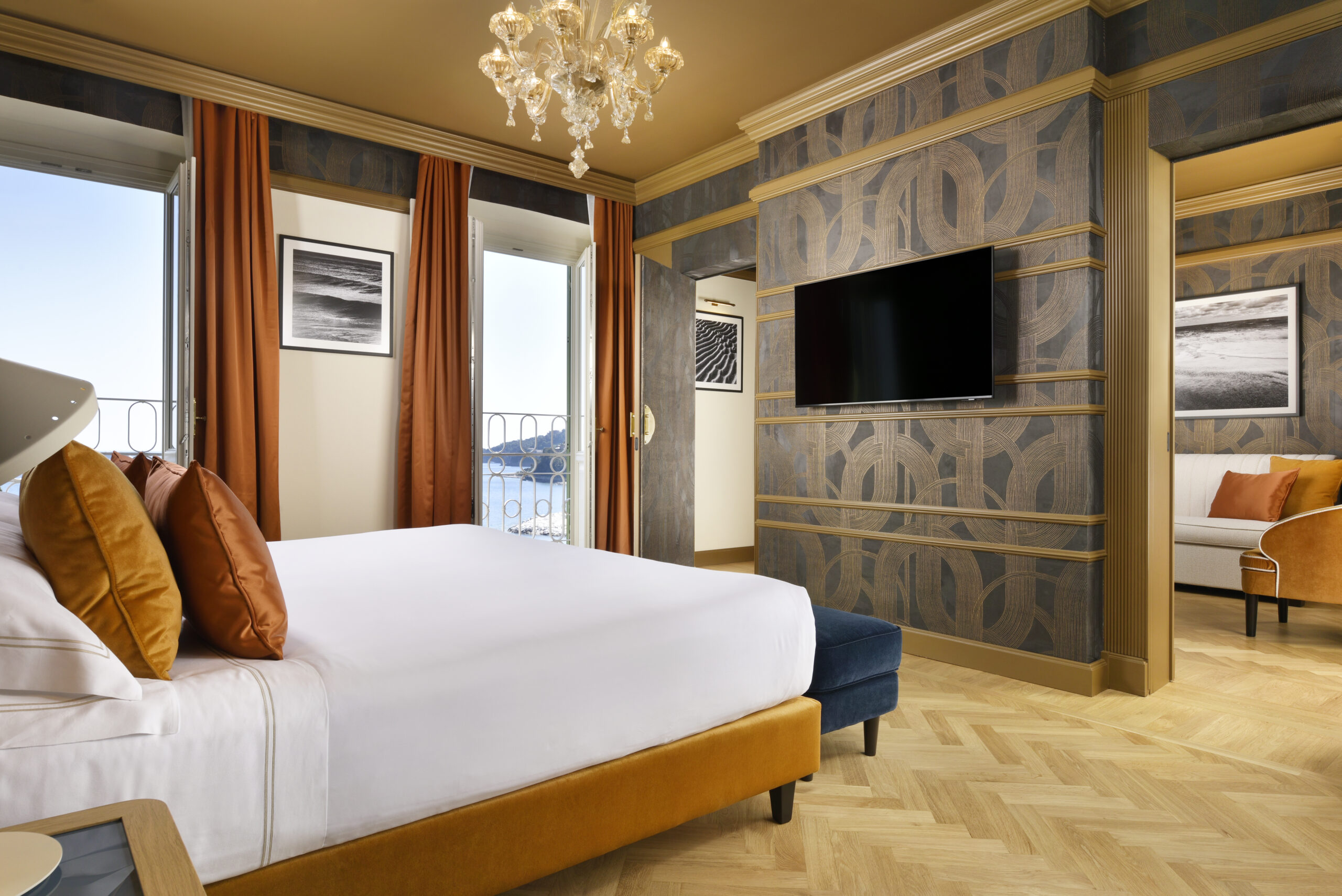 Interior of Room 419 at the Imperiale Palace Hotel with bed, decorative wall surfaces, gold details and sea view.