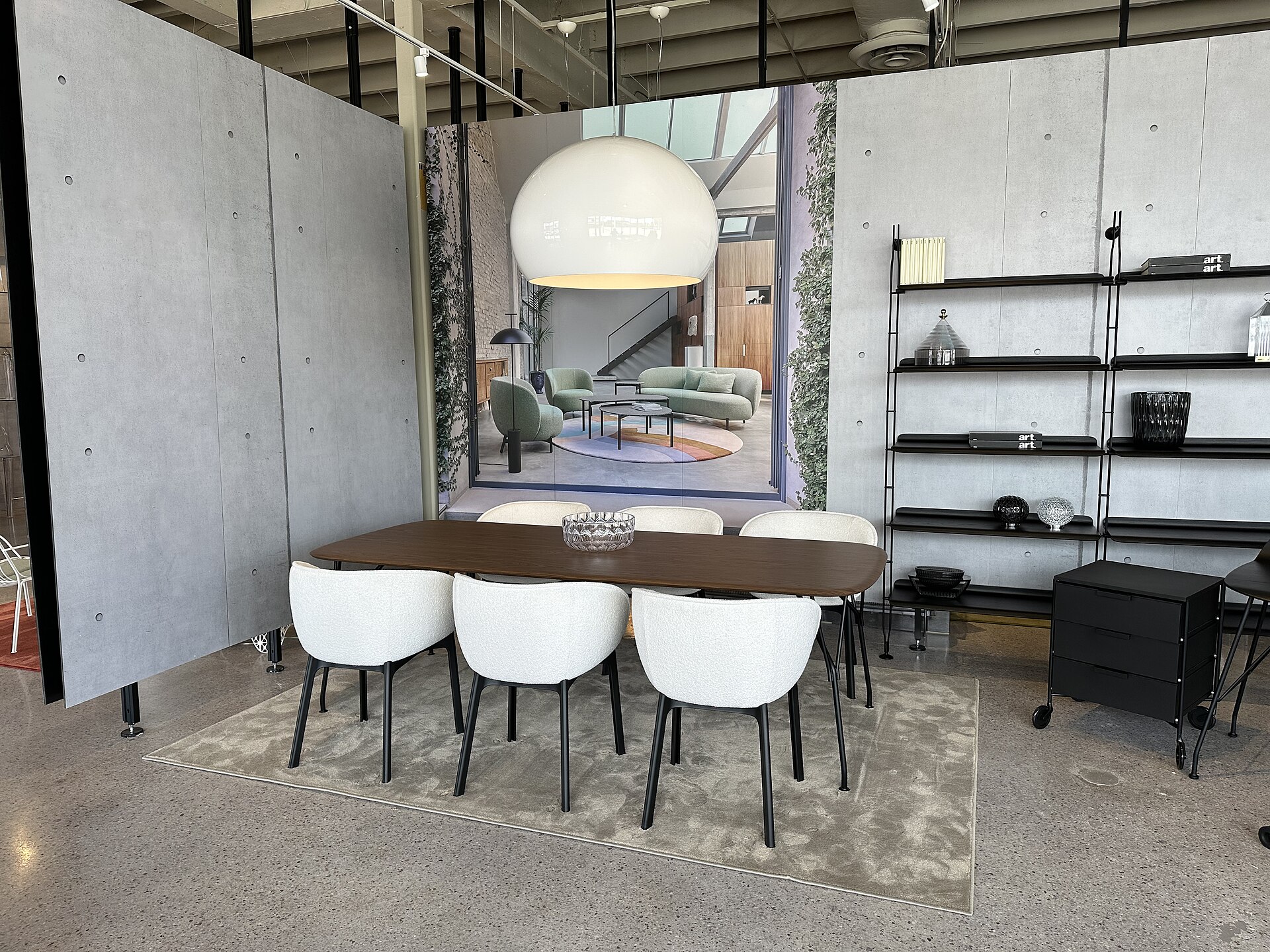 Ambientazione contemporanea con tavolo, sedie e lampade in uno showroom Kartell