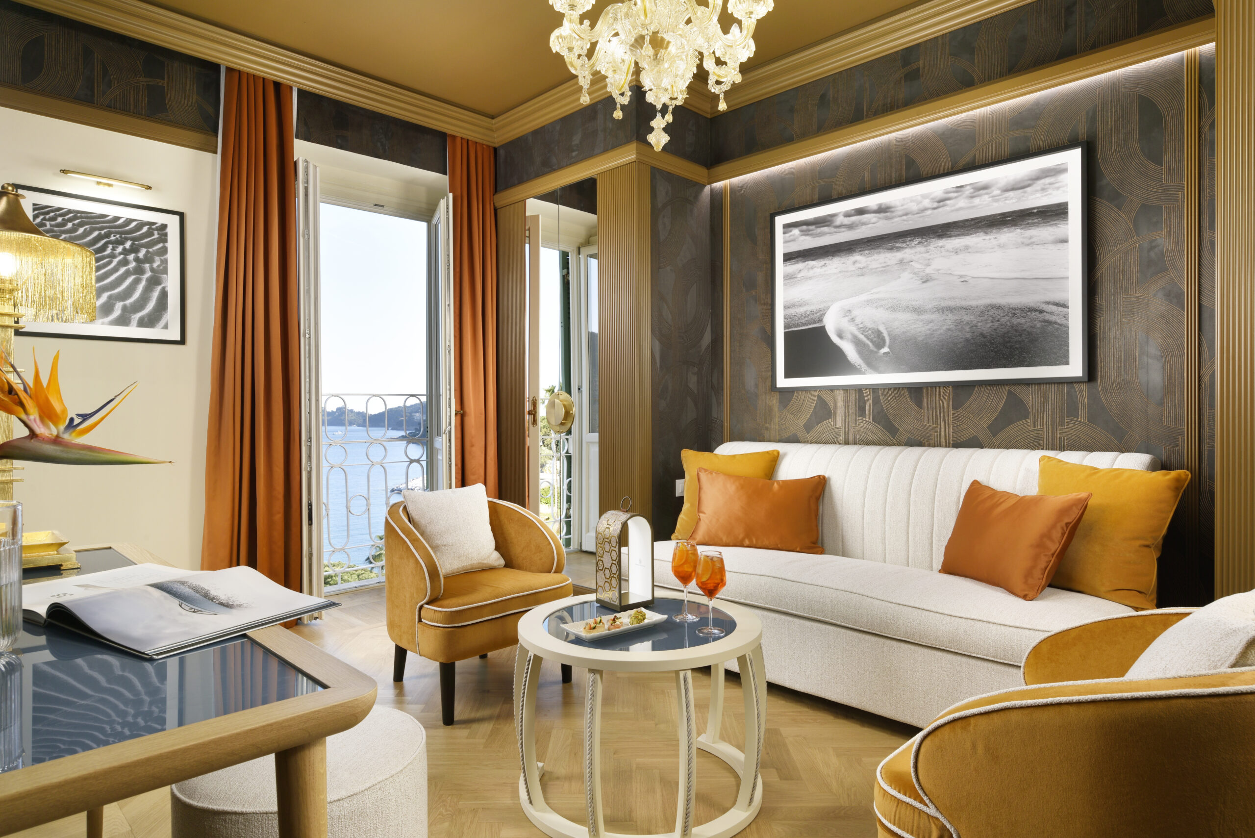 Living area of Room 419 with a light-coloured sofa, ochre armchairs, central coffee table and decorative wall surfaces.