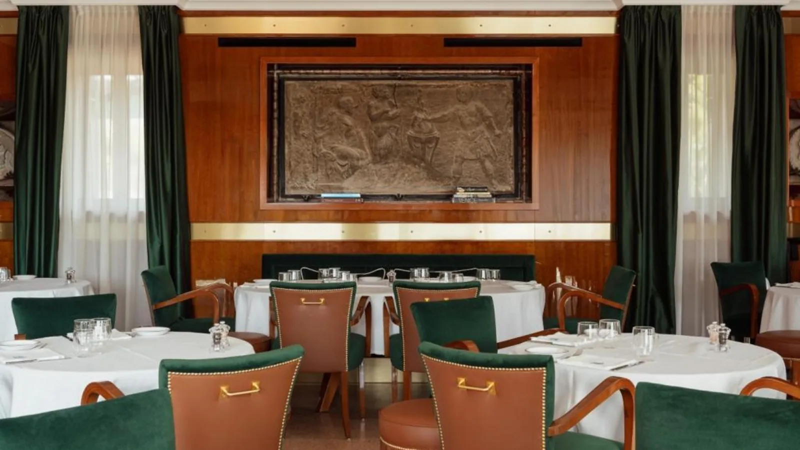 Sala da pranzo della Locanda Cipriani con pareti in legno e sedie verdi