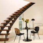 Ambiente Maisons du Monde con scala in legno, tavolo nero e sedie