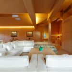 Soggiorno mansardato in legno con divani bianchi e illuminazione integrata