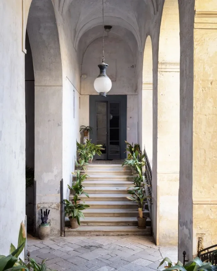 Scala verso il giardino di Palazzo Daniele tra archi e vegetazione