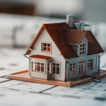 Modello di una casa posizionato su planimetrie architettoniche, simbolo della progettazione e della pianificazione di una ristrutturazione.