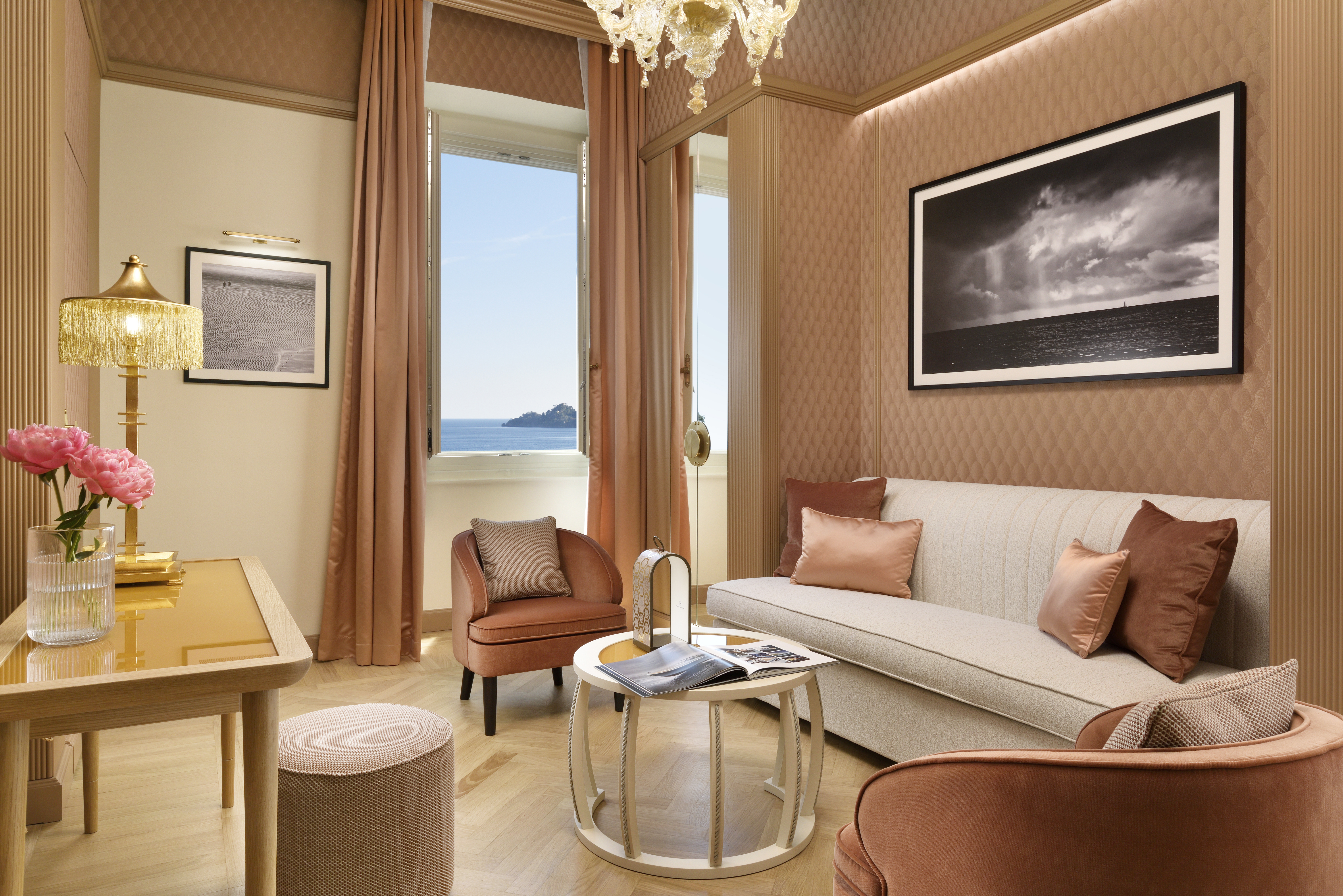 Suite 219 dell'Imperiale Palace Hotel con divano, poltrone rosa, tavolino centrale e vista sul mare.