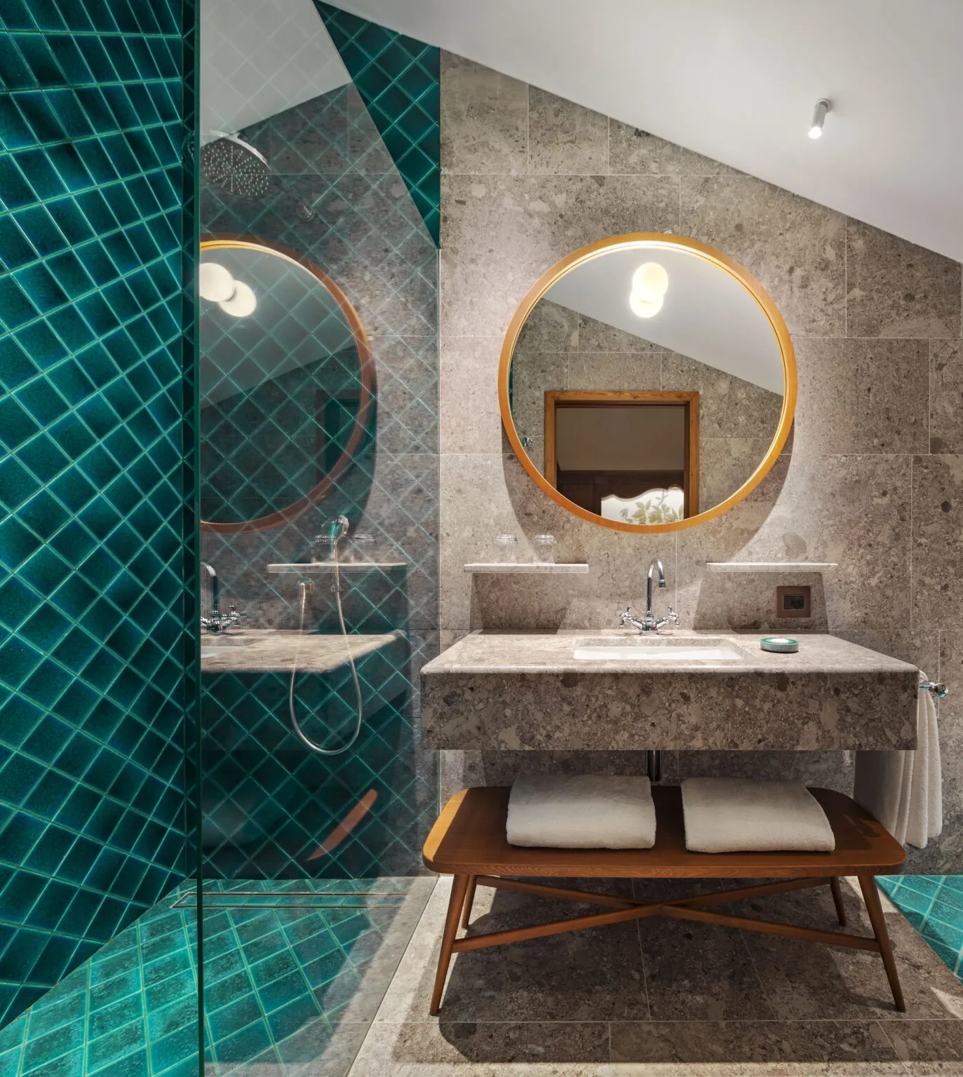 Bagno in marmo verde e pietra di una Tofane Suite al Faloria