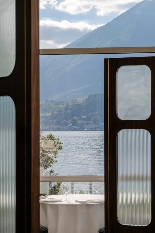 Vista sul lago di Como incorniciata dagli interni del ristorante Mistral