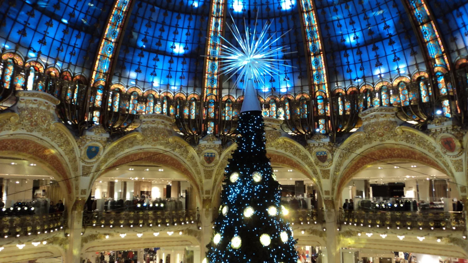 The Christmas tree beneath the Art Nouveau dome of the Galeries Lafayette Haussmann in Paris