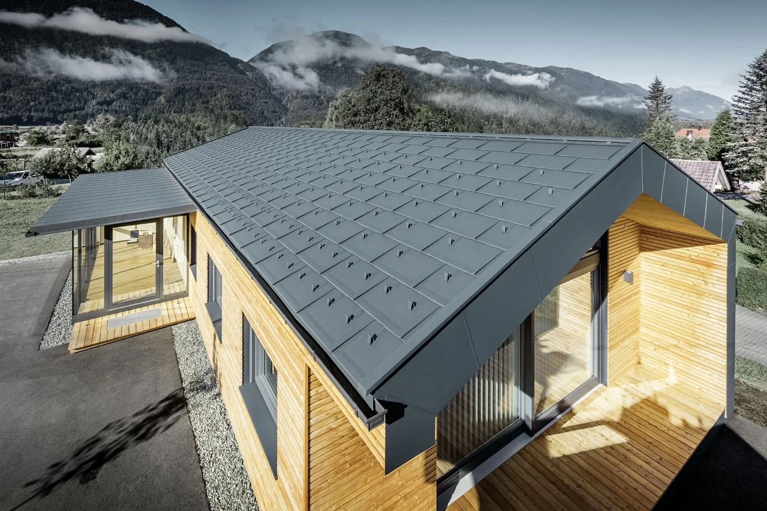 Edificio in legno con copertura metallica PREFA nel paesaggio montano