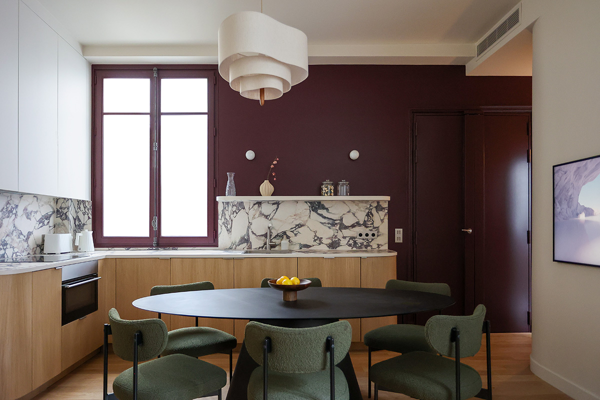 Sala da pranzo con nuance prugna e sedute verdi, progetto Atelier Tyzon