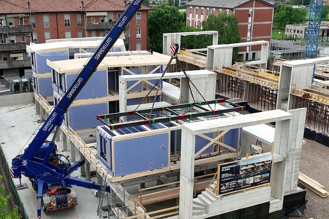 Crane installing prefabricated timber modules on site