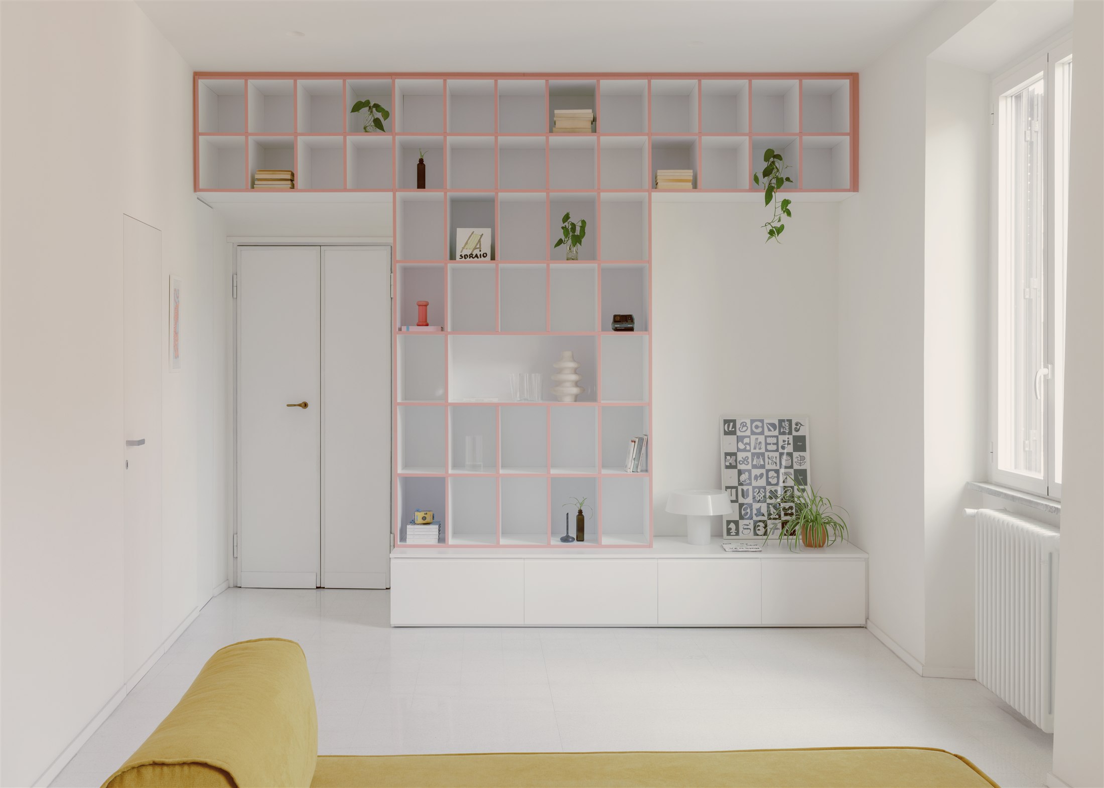 Living di Casa Tahiti con libreria e colori pastello