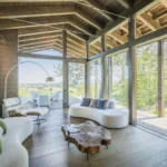 Soggiorno Rubner Haus con struttura in legno a vista e grandi vetrate sul giardino
