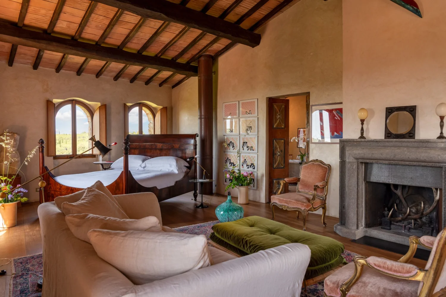 Interni di Castello di Vicarello in Maremma con travi a vista, camino e arredi di famiglia