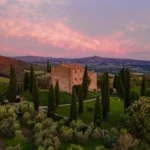 Castello di Vicarello al tramonto tra i cipressi della Maremma, dimora di campagna in Toscana