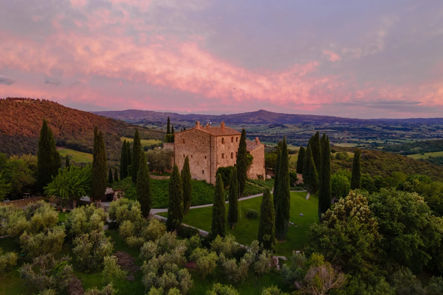 Castello di Vicarello al tramonto tra i cipressi della Maremma, dimora di campagna in Toscana