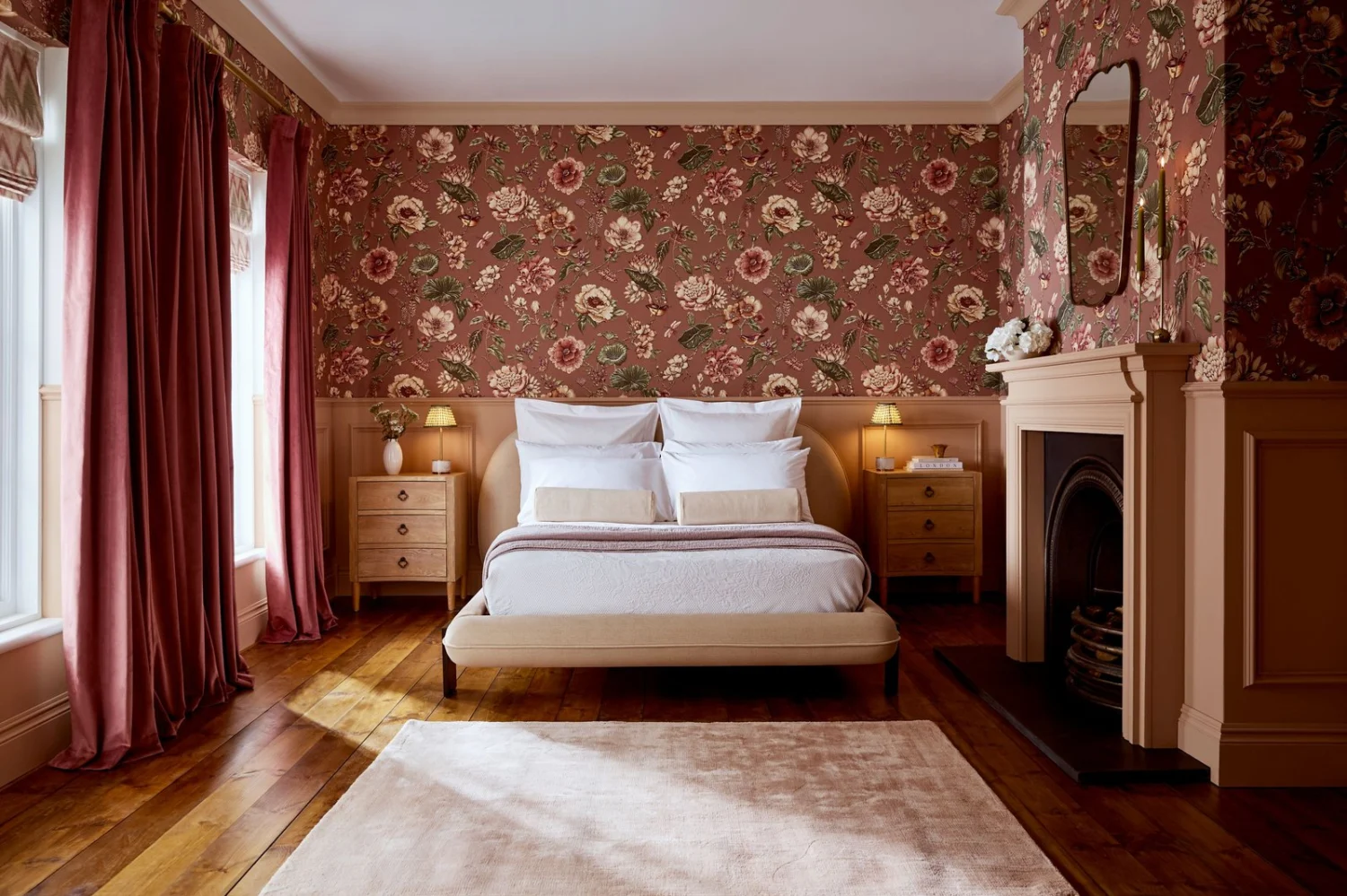 Bedroom with earthy pink walls and floral wallpaper behind the bed