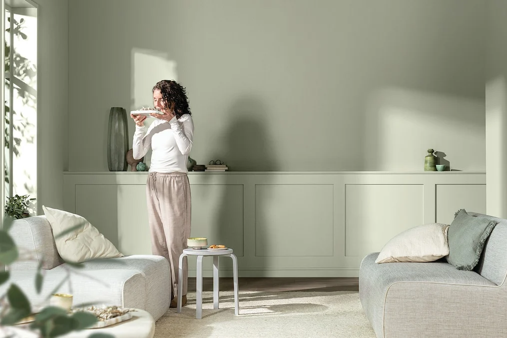 Living room with sage green walls and panelling and pale sofas
