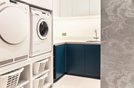 Highgate Hill laundry with blue cabinetry and Fornasetti Clouds wallpaper by Cole & Son