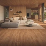 Soggiorno open space con pavimento in gres porcellanato effetto legno teak e grande divano chiaro