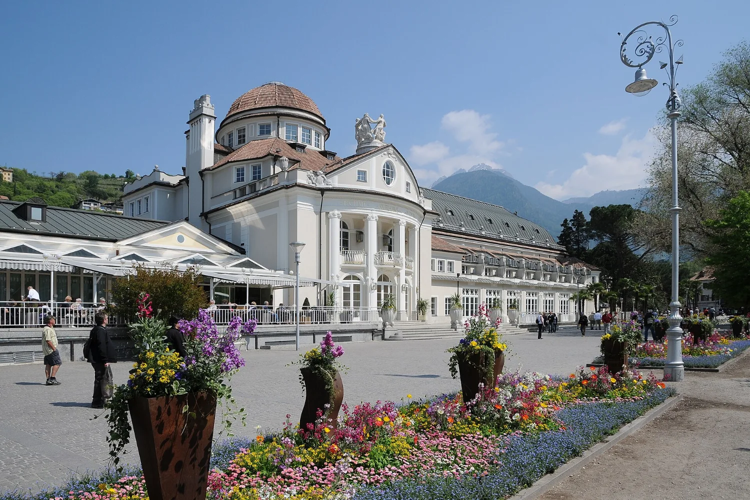 White facade of the Merano Kurhaus with its Art Nouveau dome overlooking the Passer