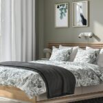 Letto matrimoniale in betulla con testiera a doghe, mensole integrate e faretti LED in una camera da letto con pareti verde salvia