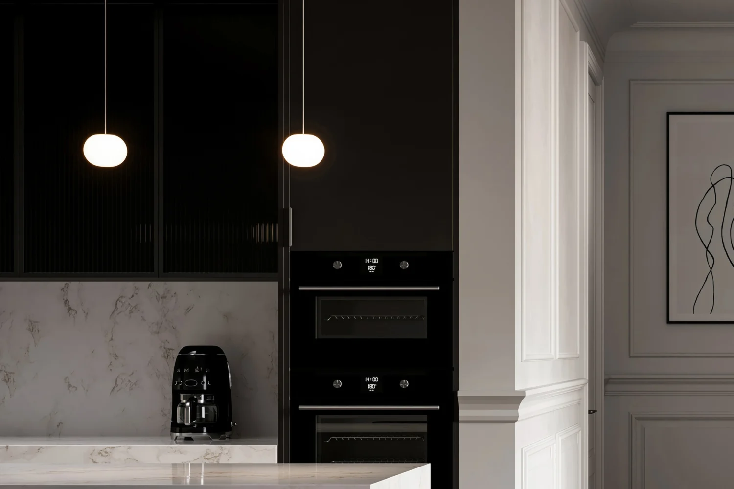 Due piccole sospensioni a sfera in vetro opale accese davanti a una cucina scura con forni in colonna