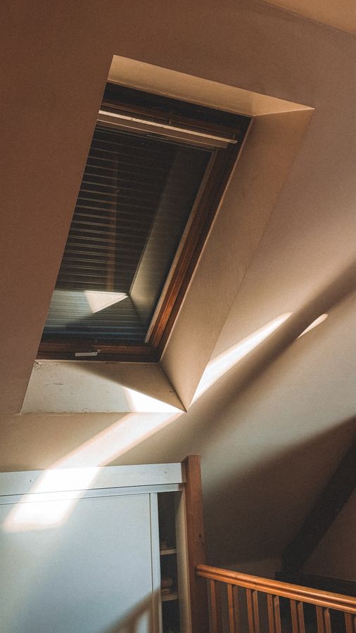 Roof window bringing natural light into a timber attic interior
