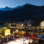 Piazza Terme a Merano a Natale con la pista di pattinaggio e le montagne al tramonto