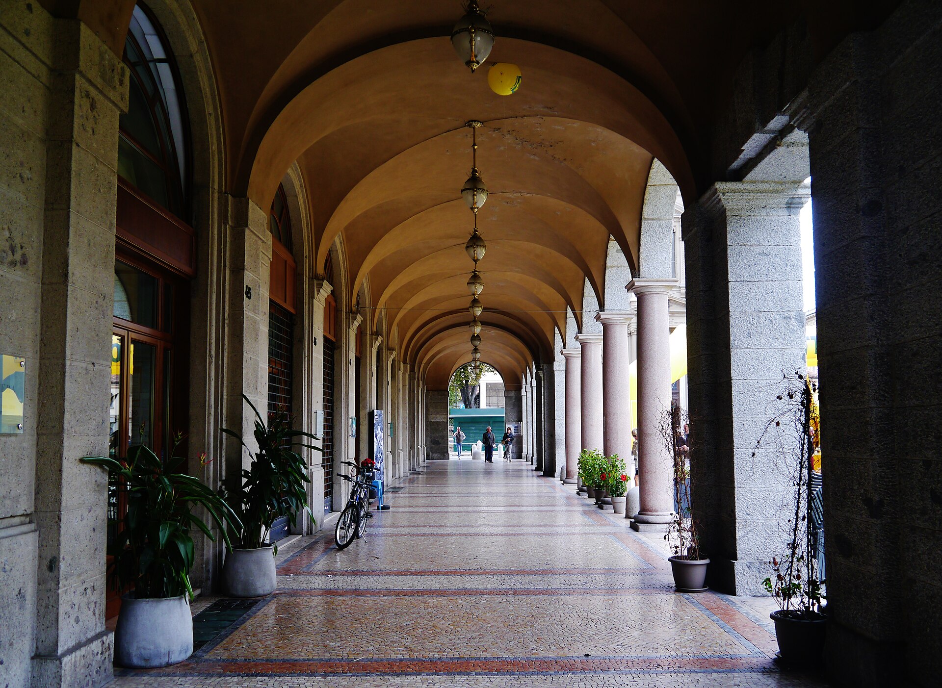 Perspective through the Sentierone arcades in Bergamo, with stone columns and vaulted ceilings